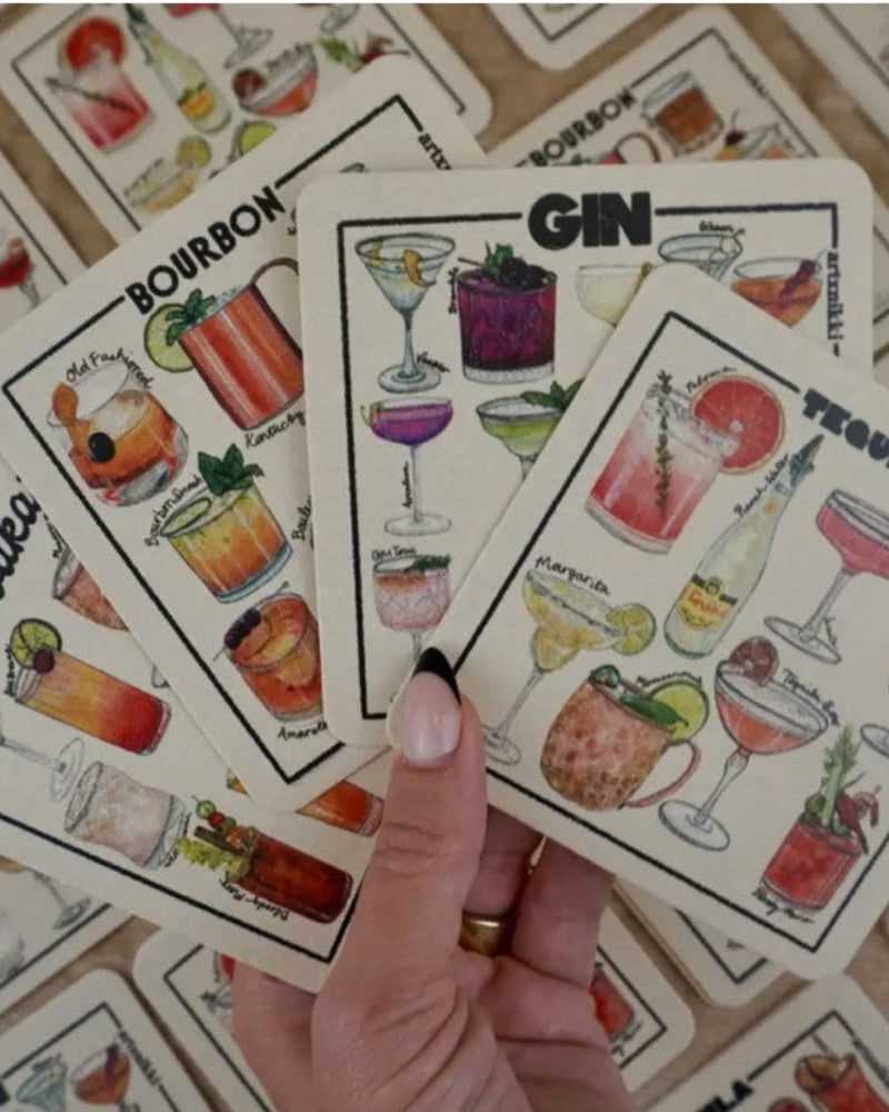 Hand holding a card with cocktail illustrations labeled 'Gin' among other cards.
