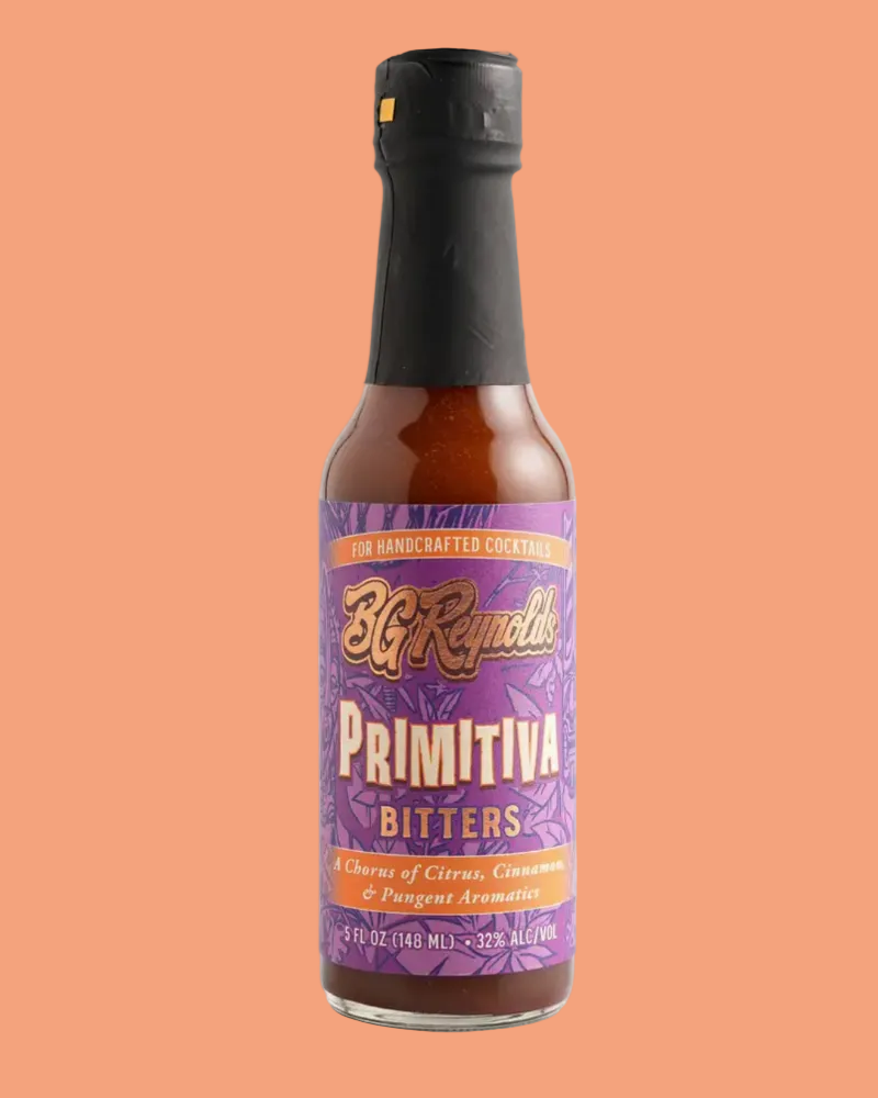A bottle of BG RENOLDS PRIMITIVA BITTERS on an orange background