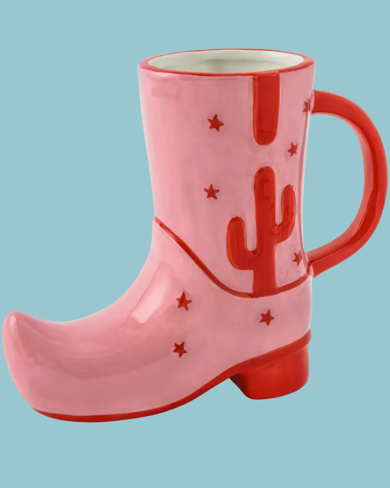 Pink mug shaped like a boot with red cactus designs on a white background