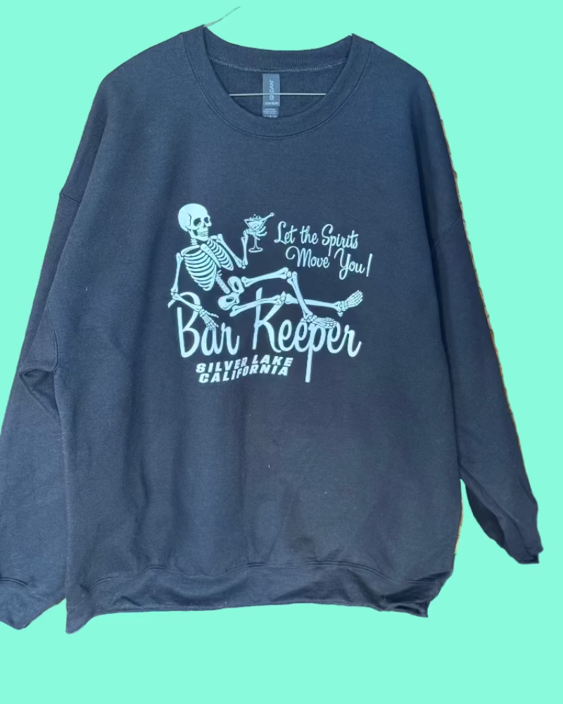 Navy blue sweatshirt with skeleton graphic and text on a teal background