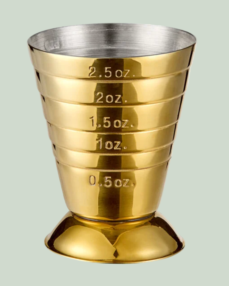Gold and silver measuring cup with measurement markings on a white background