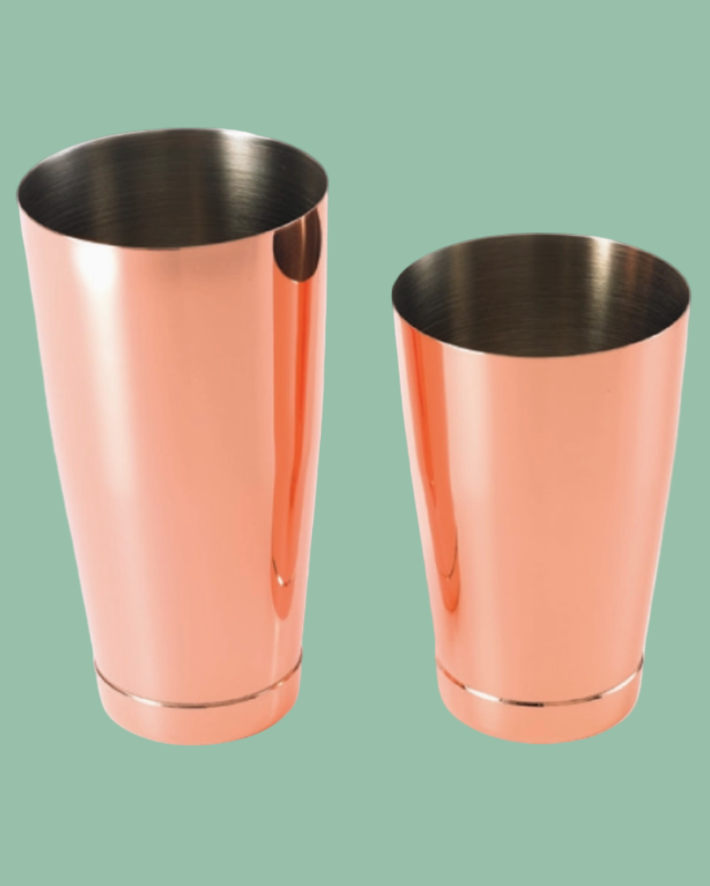 Two copper-colored metal tumblers on a green background