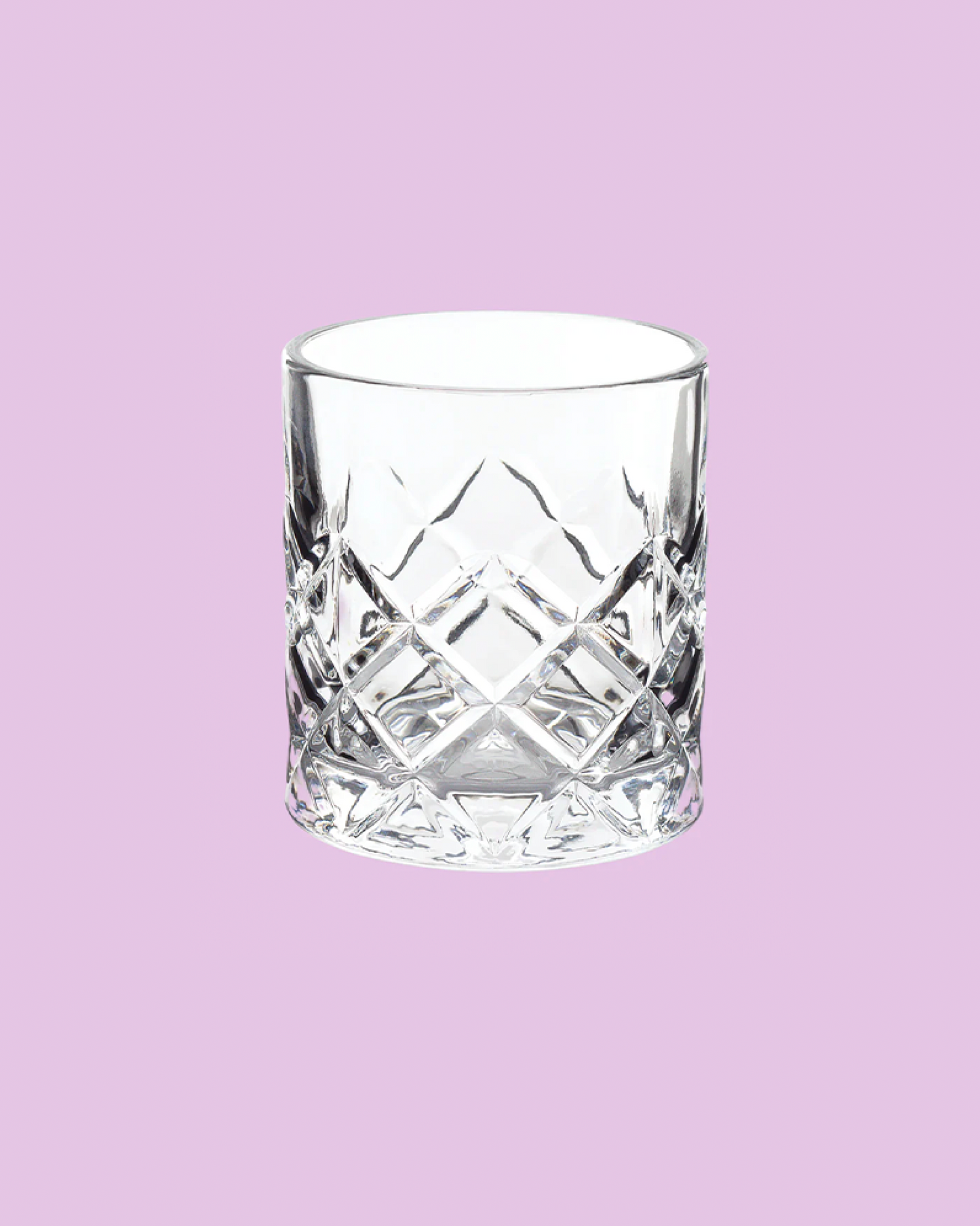 Clear glass tumbler with diamond pattern on a light purple background