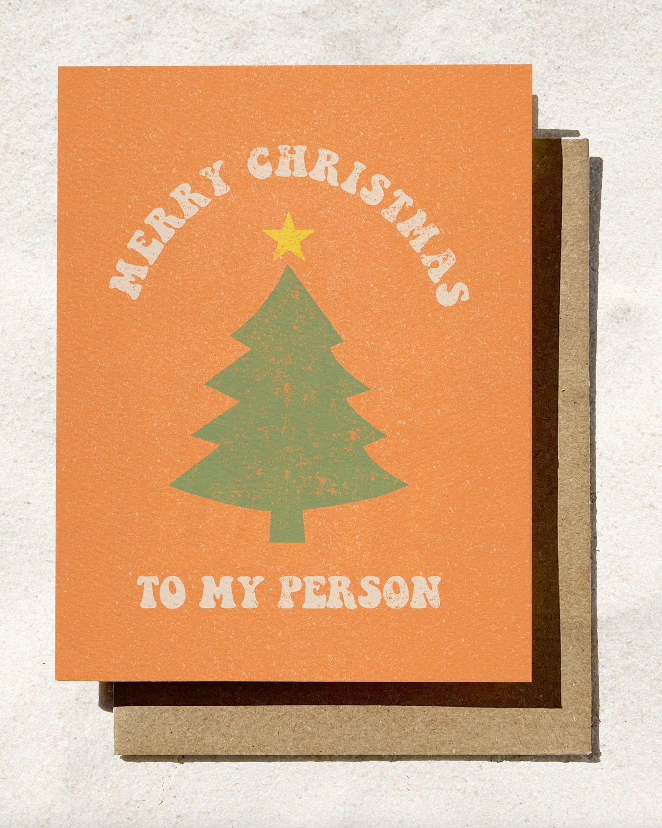 Christmas card with green tree and text on orange background