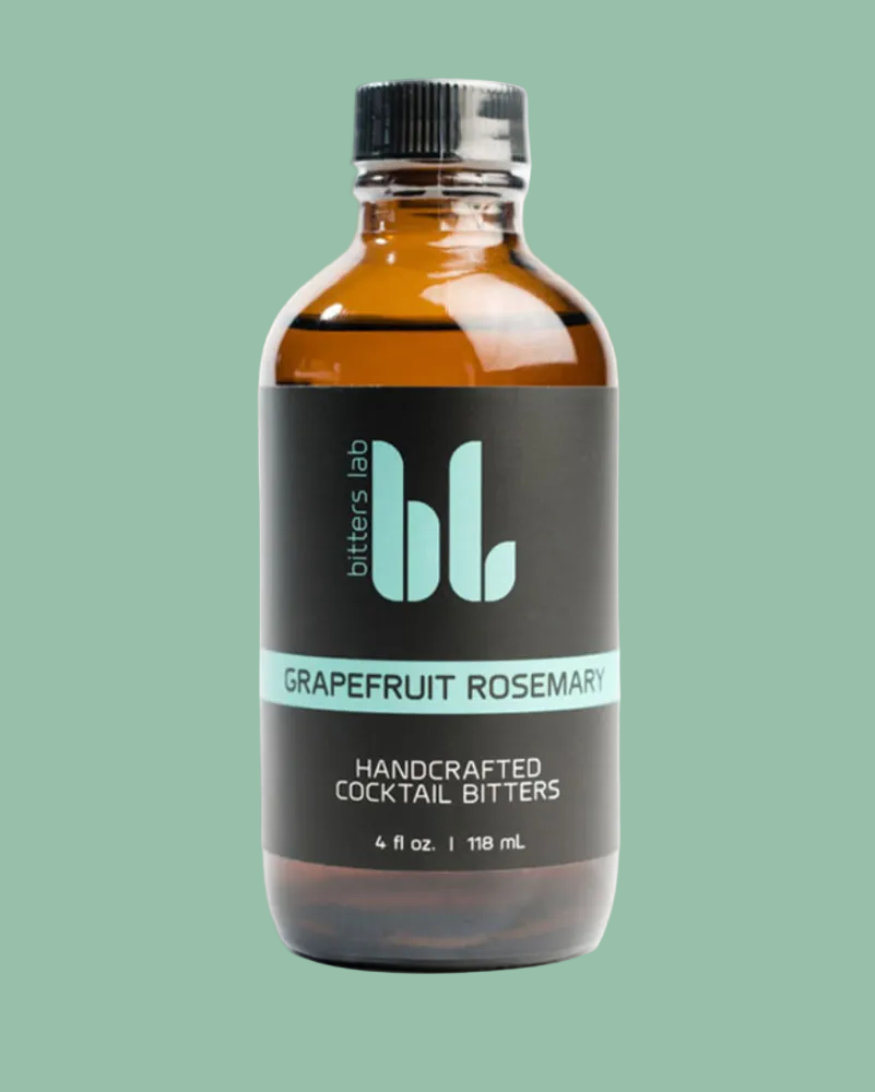 Bottle of grapefruit rosemary cocktail bitters with 'bitters lab' branding on a white background