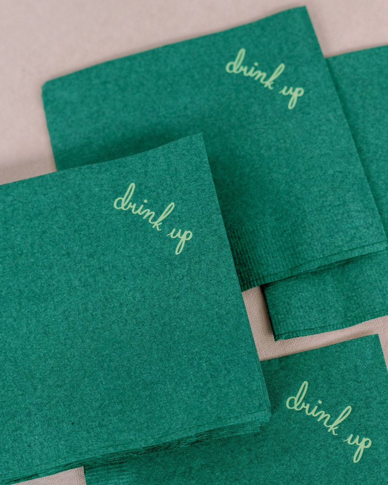 Green napkins with 'drink up' text on a beige background