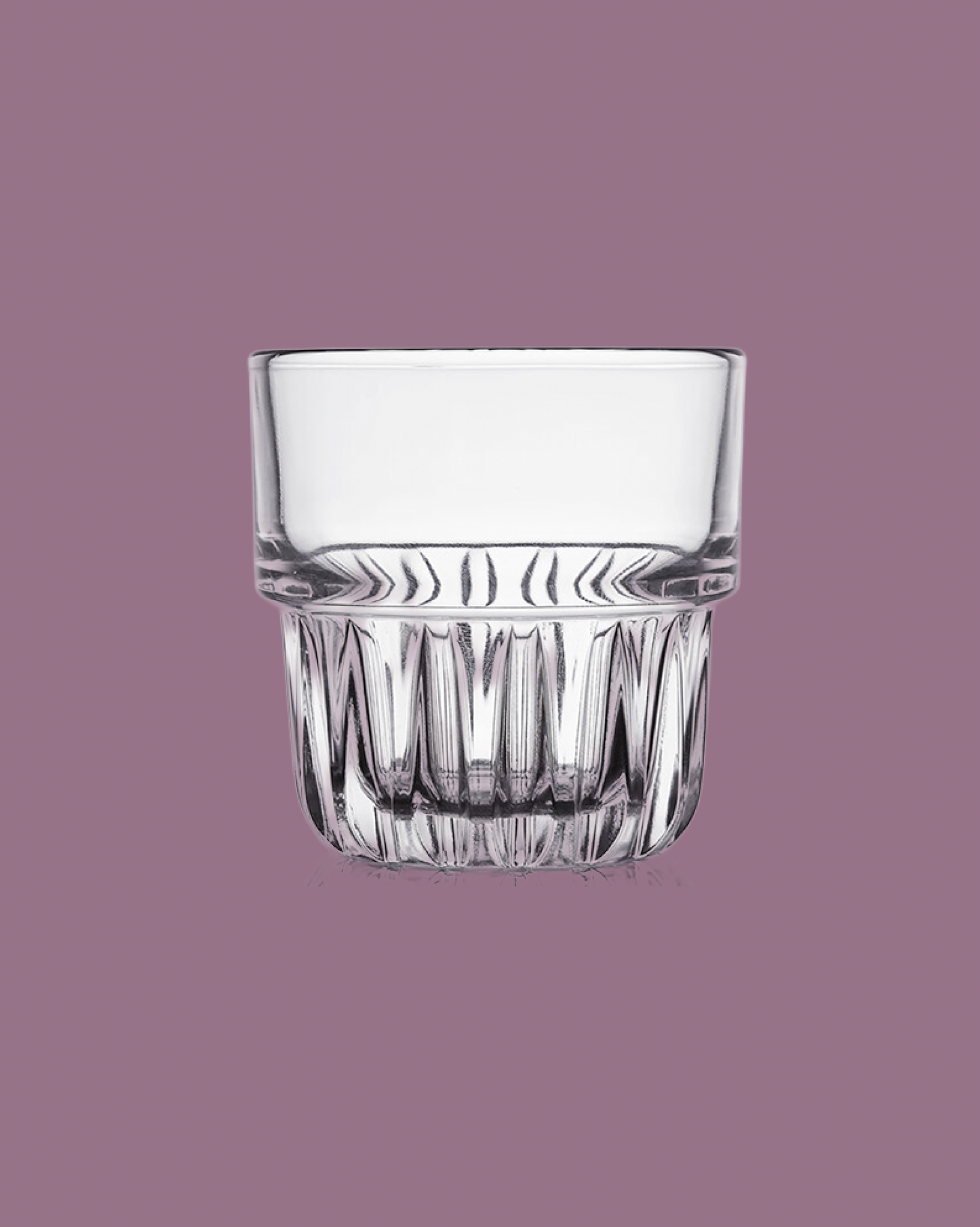 Clear glass tumbler on a purple background