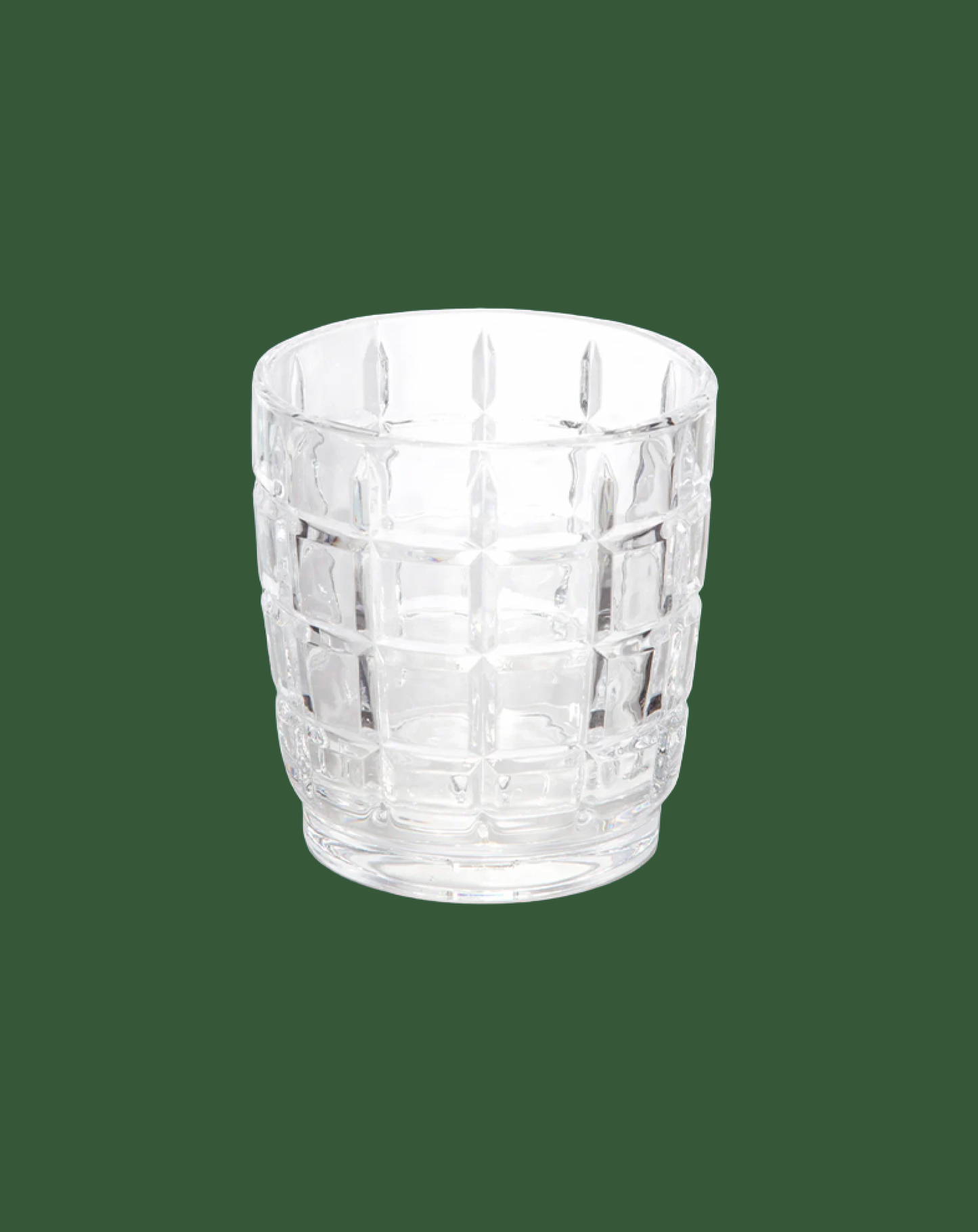Clear glass tumbler with textured design on a green background