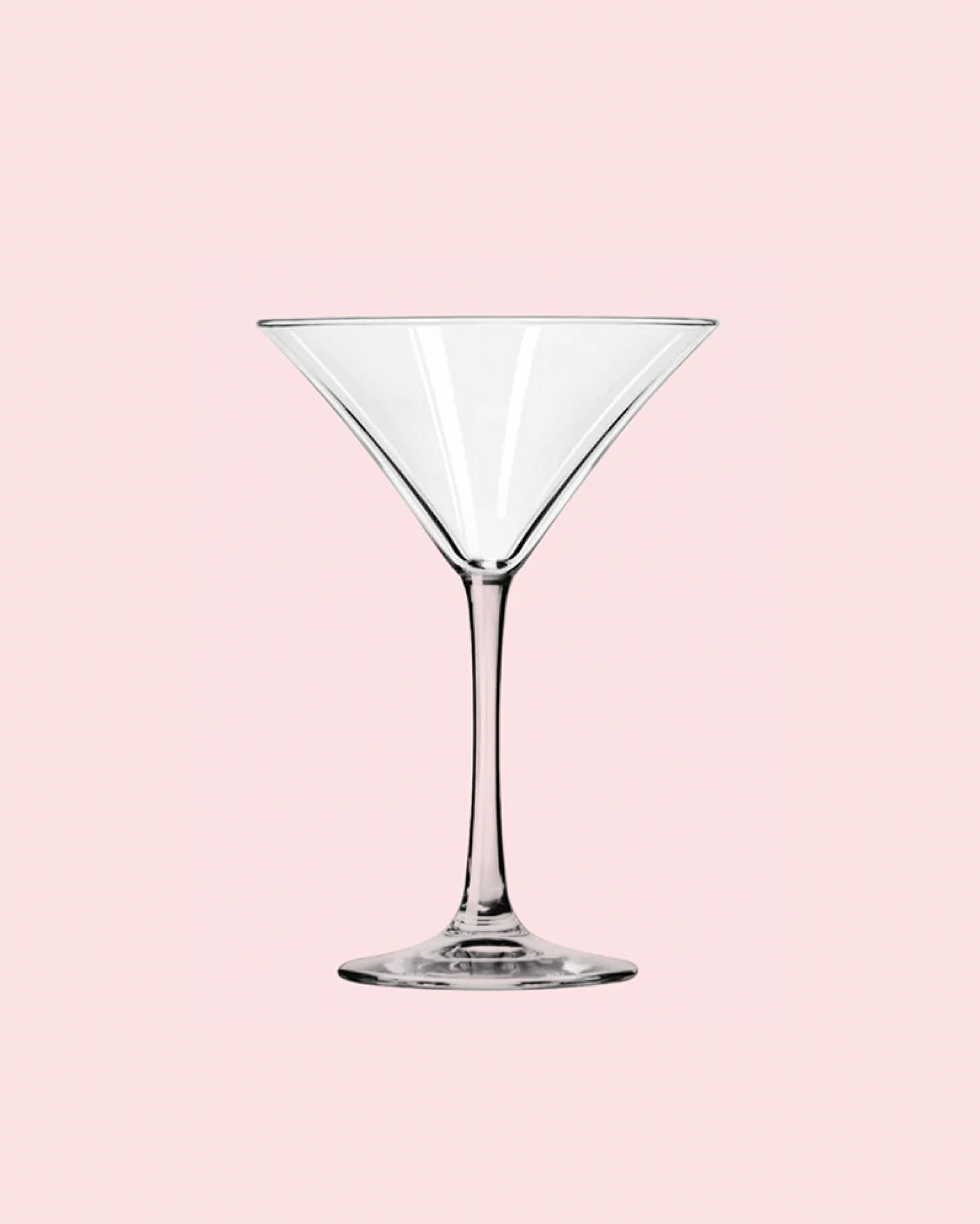 Clear martini glass on a pink background