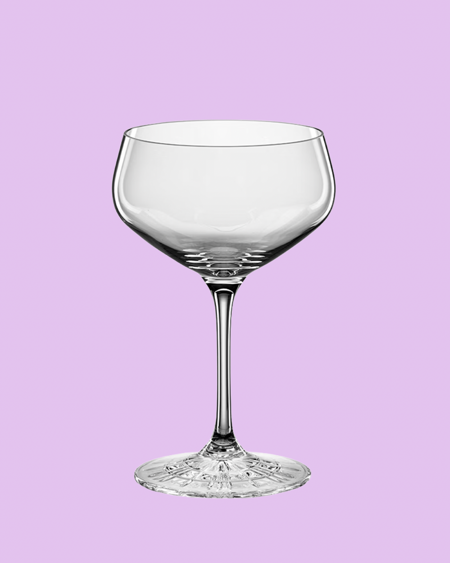 Clear glass cocktail glass on a light purple background