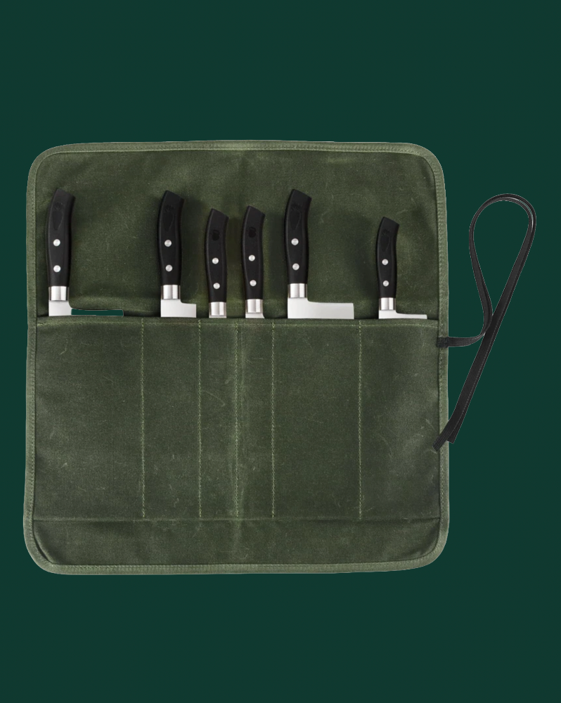 Set of knives in a green leather case on a dark green background