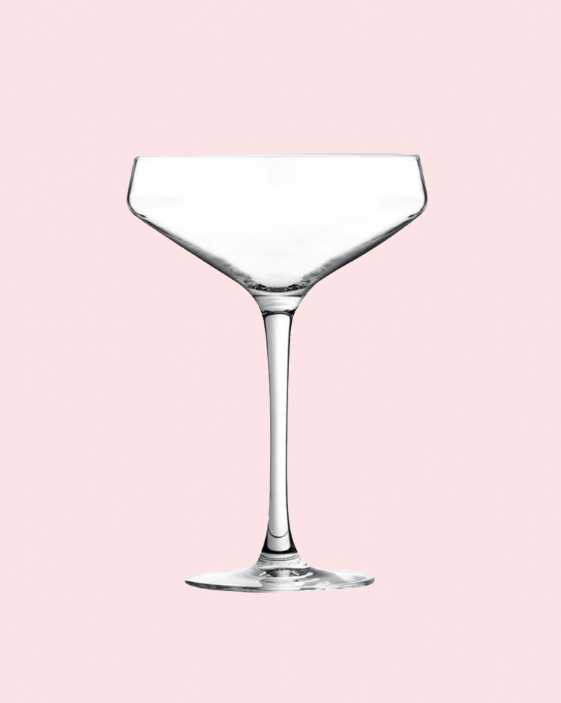 Clear wine glass on a pink background