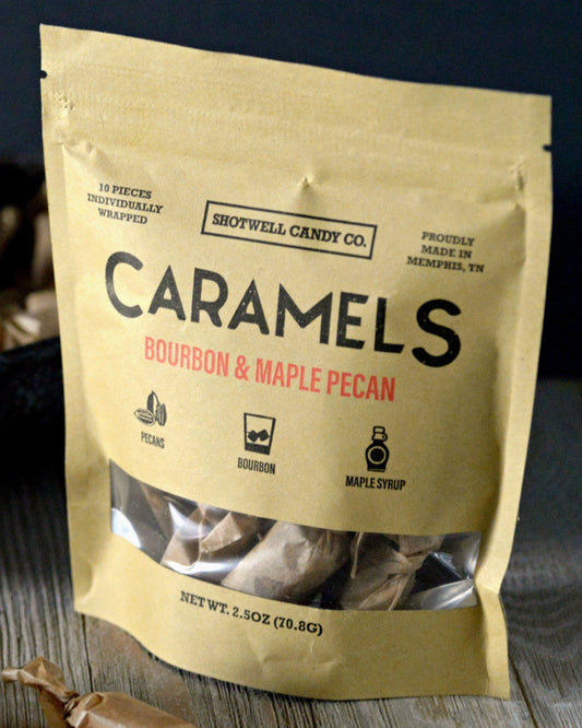 Package of Shotwell Candy Co. Bourbon & Maple Pecan Caramels on a wooden surface.