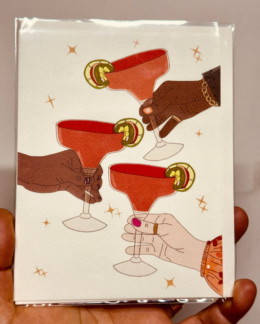 Pack of cards with illustrated hands holding cocktail glasses on a beige background
