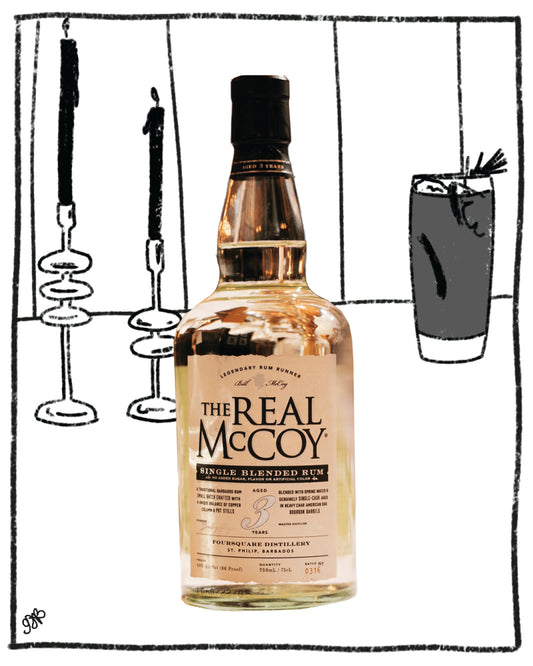 Bottle of 'The Real McCoy' single-blended rum with a cocktail glass and candles in the background.