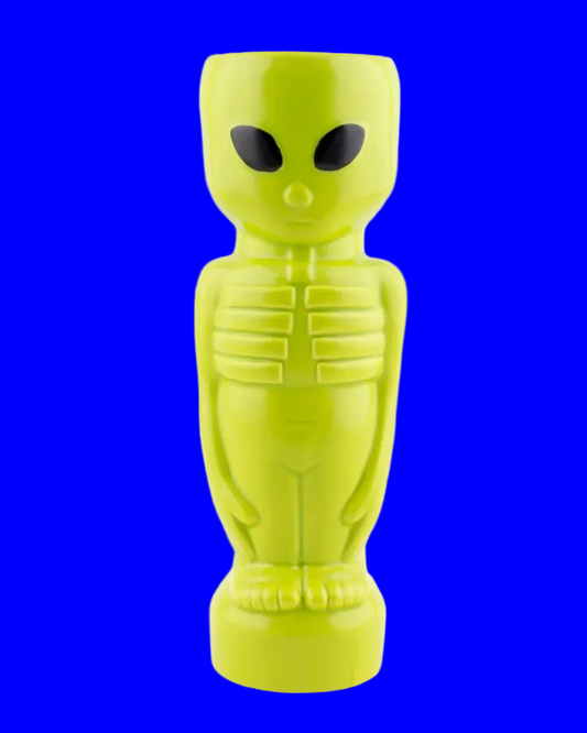 A bright lime green alien-shaped tiki mug with black eyes, standing on a white background.