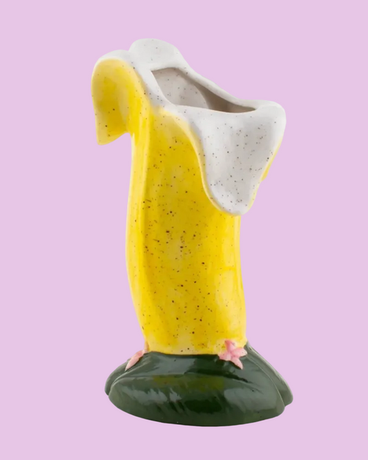 Ceramic vase shaped like a banana with a white top on a white background