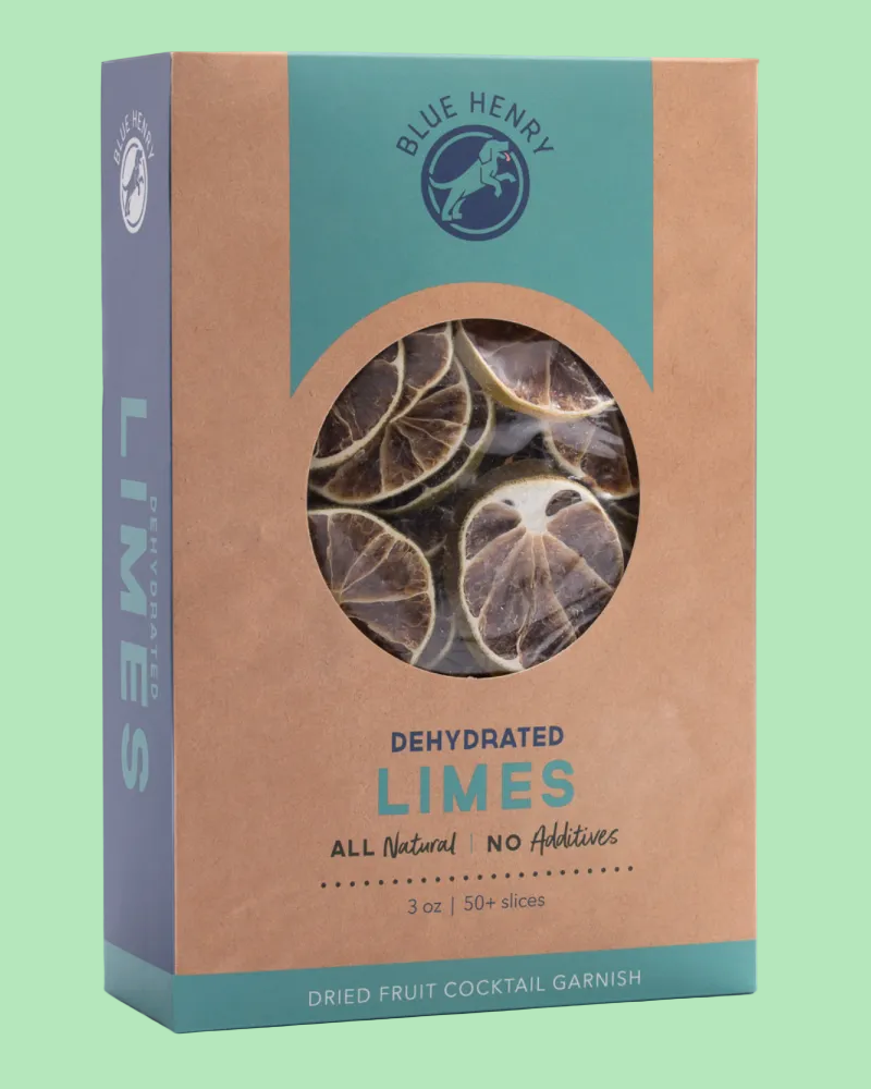 Blue Henry Dehydrated Limes cocktail garnish in a brown kraft paper box with a teal blue band and a circular window showing dried lime slices inside.