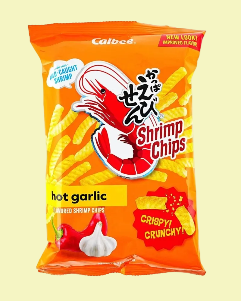 A bag of Calbee Shrimp Chips hot garlic flavor, featuring a bright orange packaging design with a cartoon shrimp, yellow chips, and garlic illustrations on a pale yellow background.