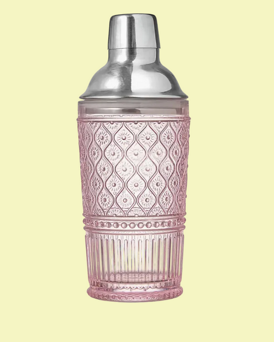 A pink textured glass cocktail shaker with a silver metal lid, set against a plain white background.