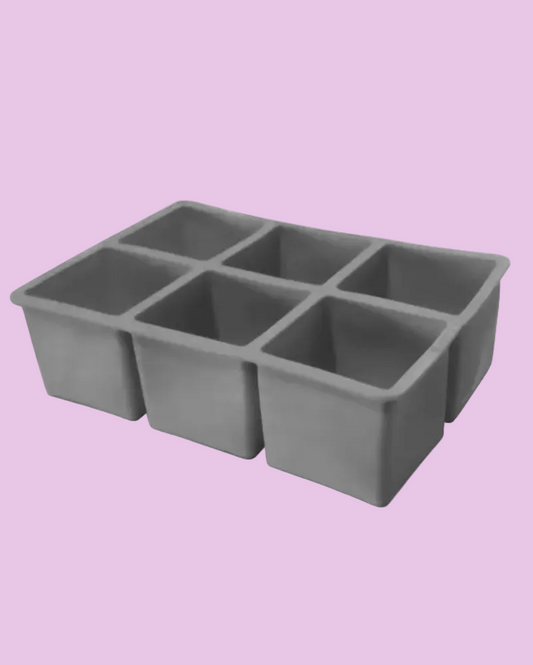 A gray silicone mold with six square compartments, shown from an elevated angle on a plain white background.