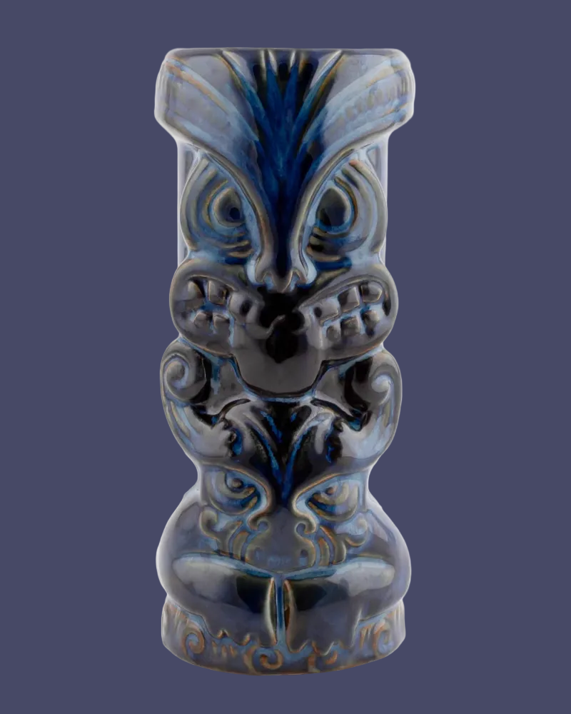 Blue ceramic tiki mug with face design on a white background