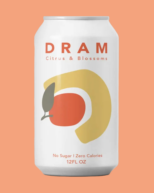 A 12 fl oz aluminum can of DRAM Citrus & Blossoms non-alcoholic citrus drink, featuring a white label with a stylized yellow and orange graphic of a citrus fruit and a leaf.