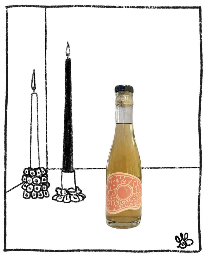 Bottle of white wine with a label next to two black candles on a white background