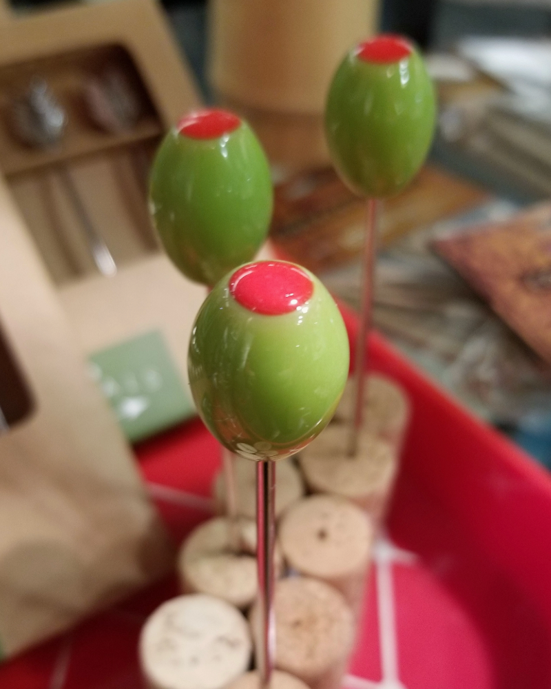 Green and red spherical objects on sticks with a blurred background