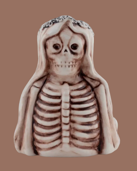 A small decorative figurine of a skeleton woman with a floral crown, shown against a plain white background.