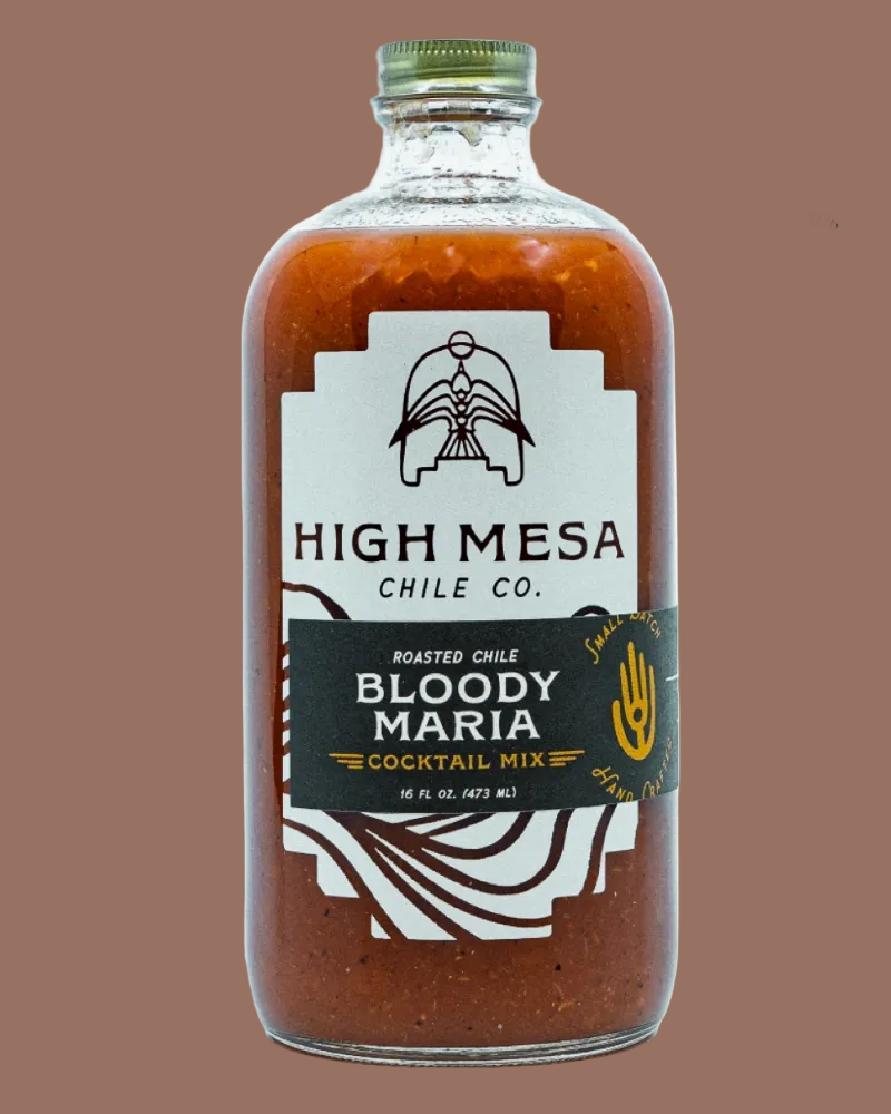 A bottle of High Mesa Chile Co. Bloody Maria Cocktail Mix, filled with a reddish-brown sauce, featuring a white and black label with a gold seal in the top right corner.