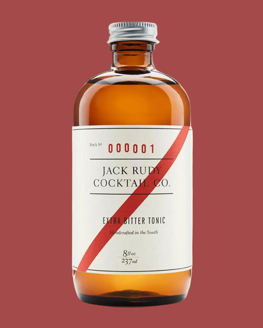 A 57ml amber glass bottle of Jack Rudy Cocktail Co. Extra Bitter Tonic with a cream label and a diagonal red stripe, set against a plain white background.