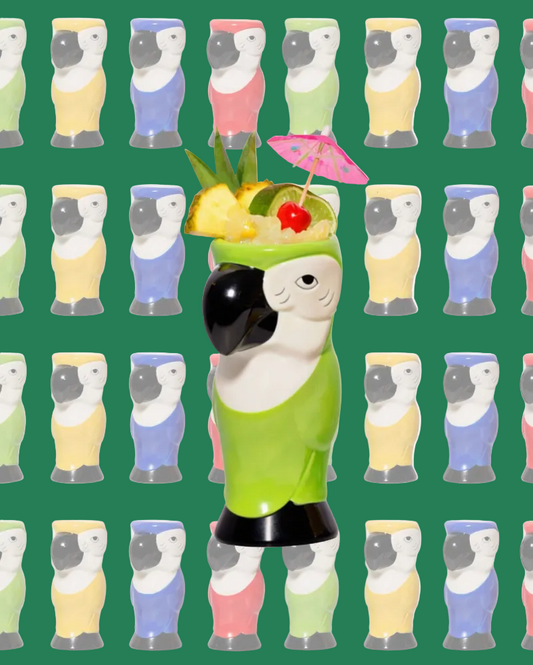 Decorative figure of a parrot with a cocktail on a green background with repeated parrot pattern