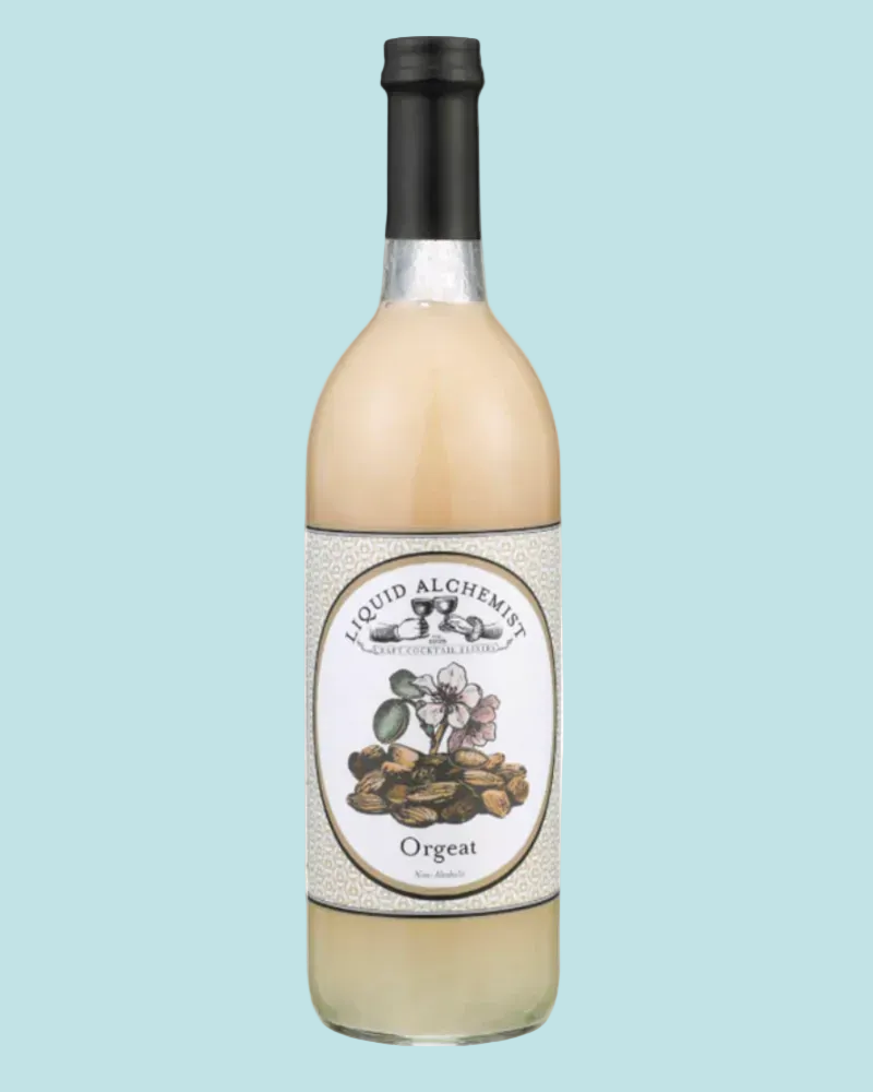 A bottle of Liquid Alchemist Orgeat liqueur with a black cap and a cream-colored label featuring botanical illustrations, set against a solid light blue background.