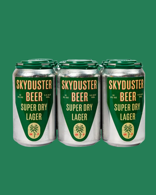 Six aluminum cans of Skyduster Beer Super Dry Lager arranged in a row against a solid green background.