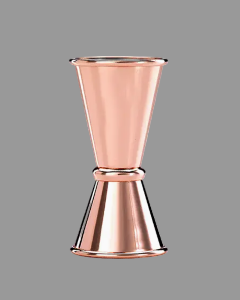 Copper jigger on a gray background