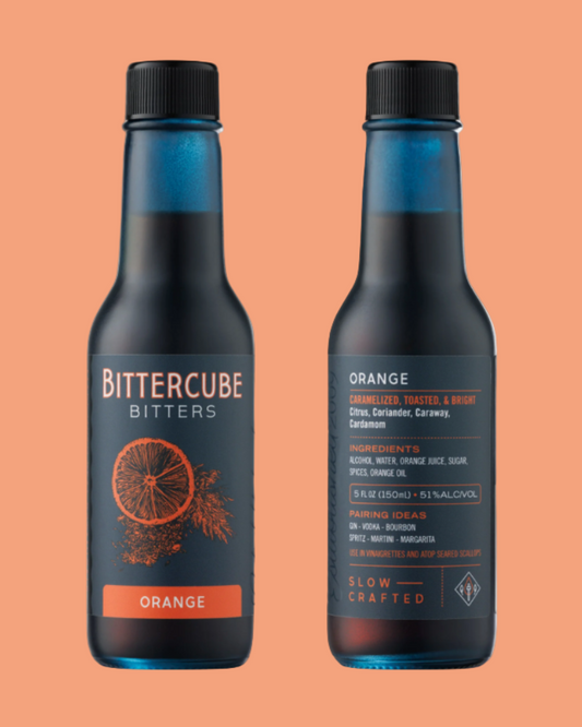 Two bottles of Bittercube Orange bitters on an orange background