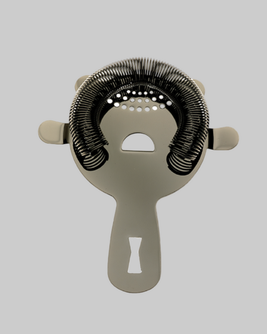 Metallic cocktail strainer on a light gray background