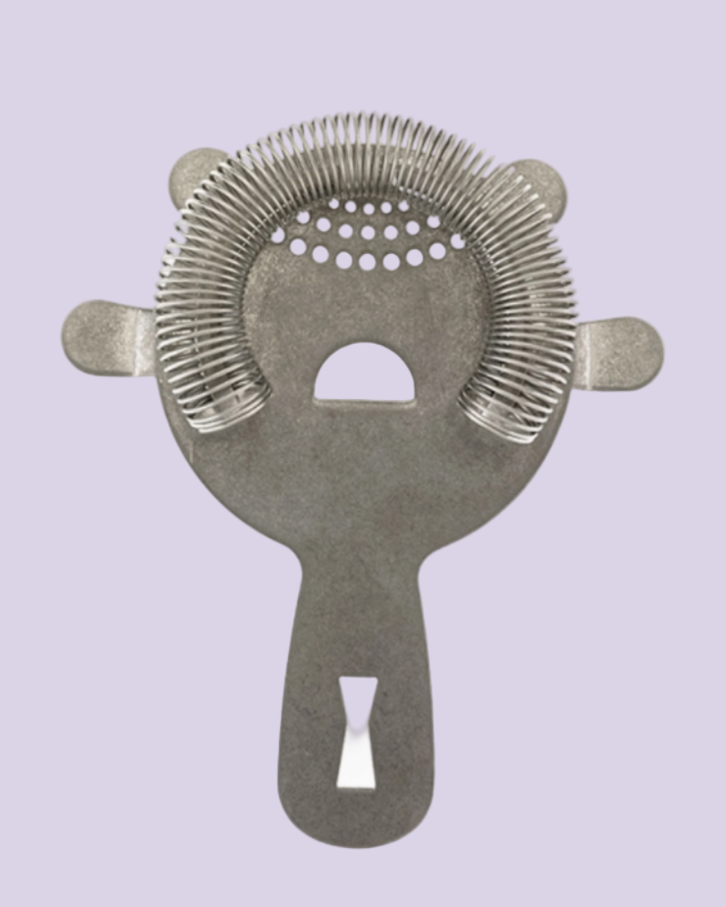 Metallic cocktail strainer on a light purple background