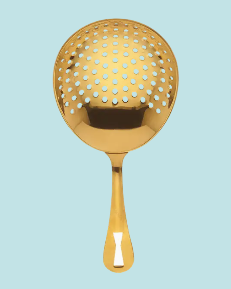 Gold metal strainer on a light blue background