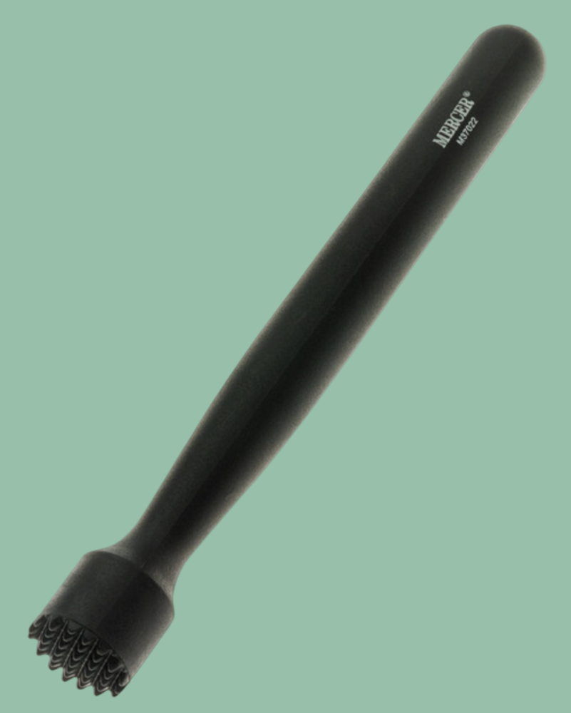 Black massage tool with textured head on a green background