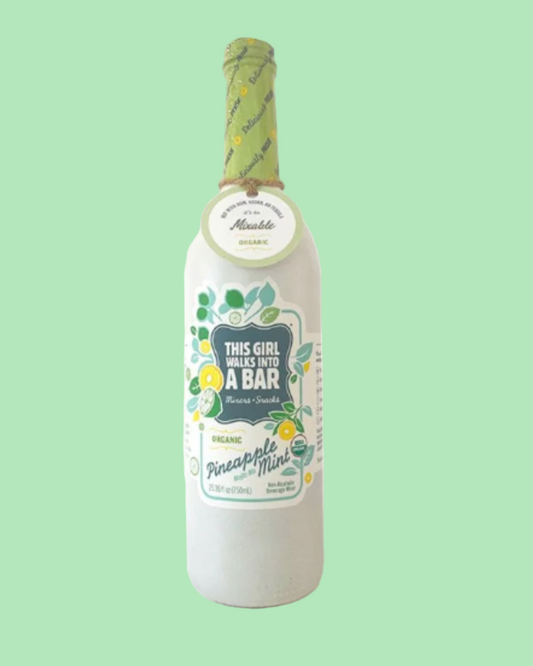 Bottle of pineapple mint liqueur with a decorative label on a light green background