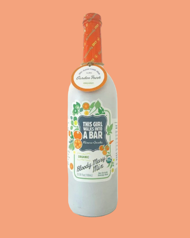 Bottle of 'This Girl Walks Into A Bar' Bloody Mary Mix on a peach background