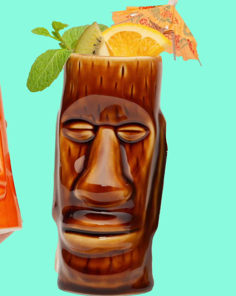 Tiki mug with a face design filled with a cocktail on a teal background