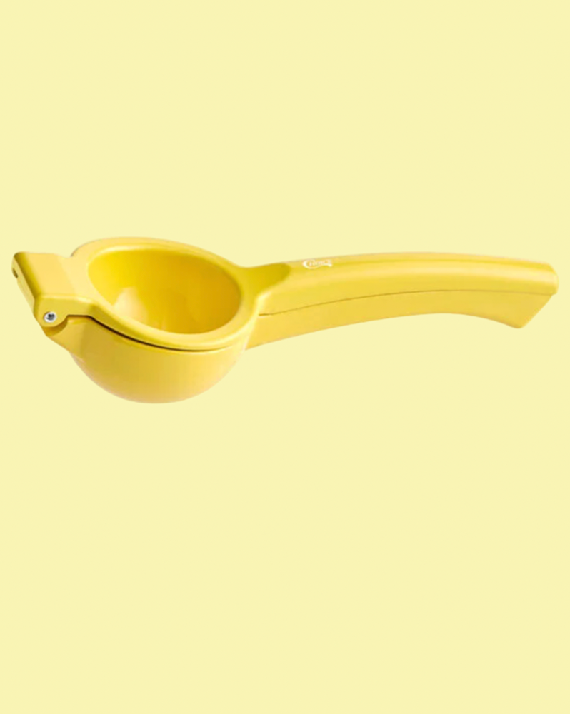 yellow garlic press on a yellow ackground