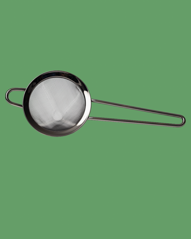 Metal strainer with a handle on a green background