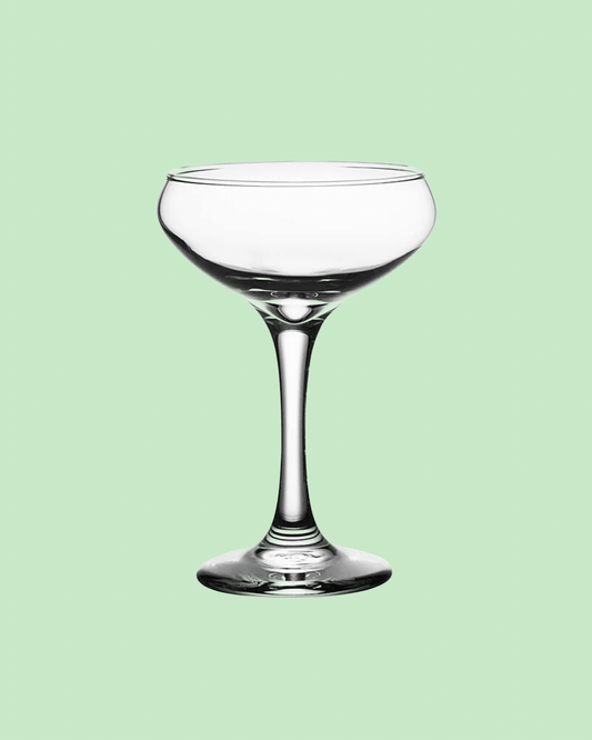 tall coupe wine glass on a green background