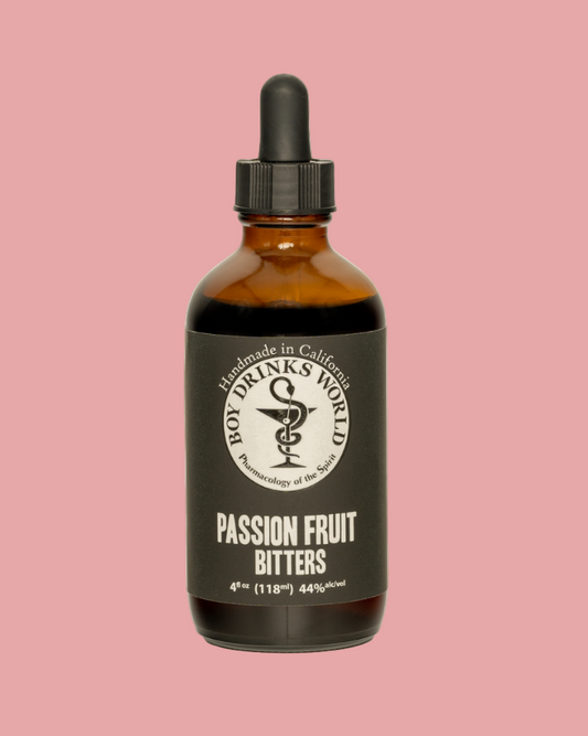 Bottle of passion fruit bitters with a black label on a pink background
