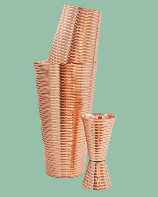 Stack of rose gold plastic cups on a green background