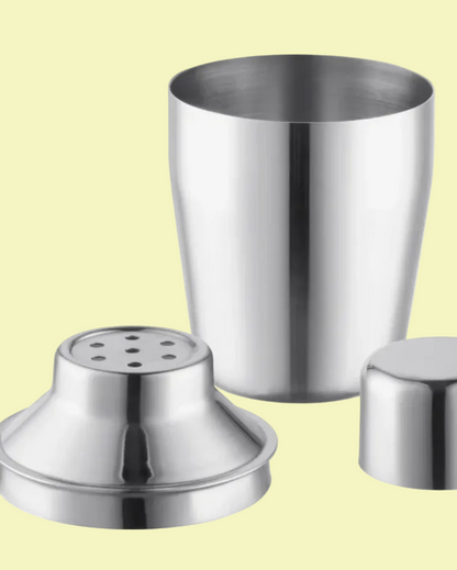 Set of three stainless steel kitchen items including a large container, a small container, and a shaker on a light yellow background.
